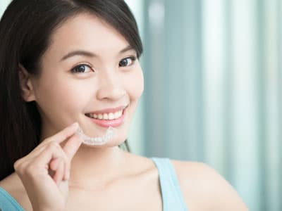 woman holding invisalign